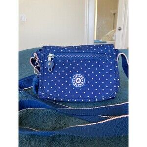 Kipling Sabian small flap crossbody bag in navy blue with pink polka dots.